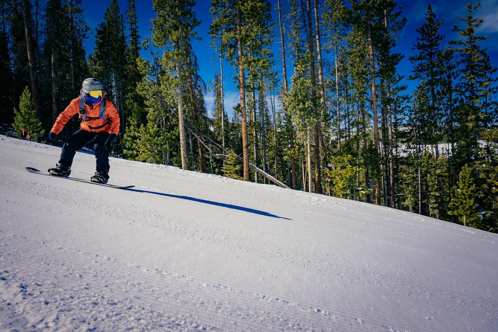 A person riding a snowboard down a snowy slope