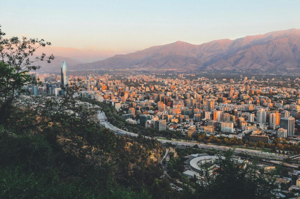 Breathtaking view of Santiago, Chile's skyline framed by mountains at sunset.