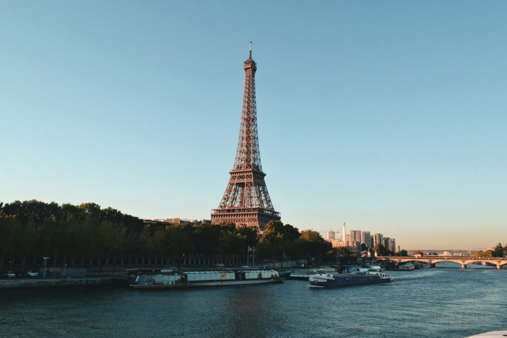 Scenic view of the Eiffel Tower and Seine River at sunset, showcasing iconic Parisian architecture.