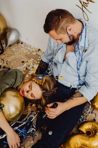 A couple sleeping amid confetti after a wild New Year's Eve party.