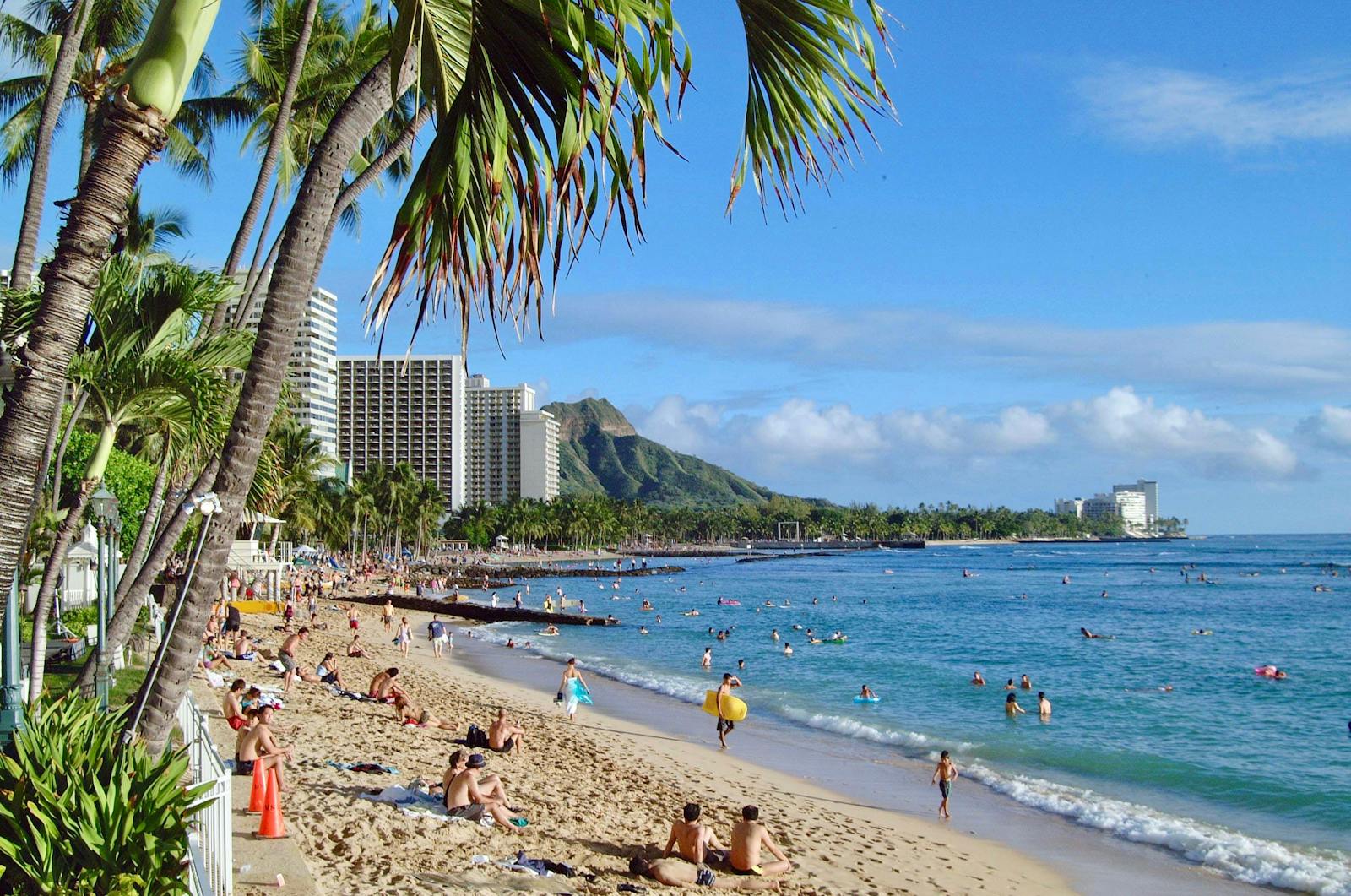 Vibrant scene of people enjoying Waikiki Beach under the tropical sun in Oahu, Hawaii. Travel to Hawaii.