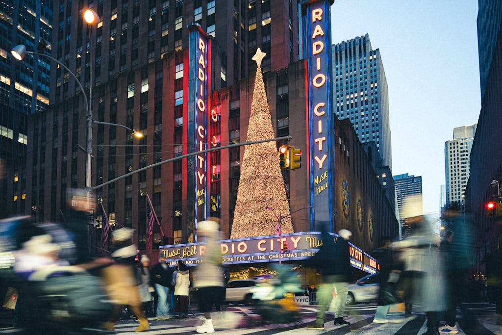 Radio City Music Hall decorated for Christmas in New York City with a lit Christmas tree and bustling crowds. New York itinerary.