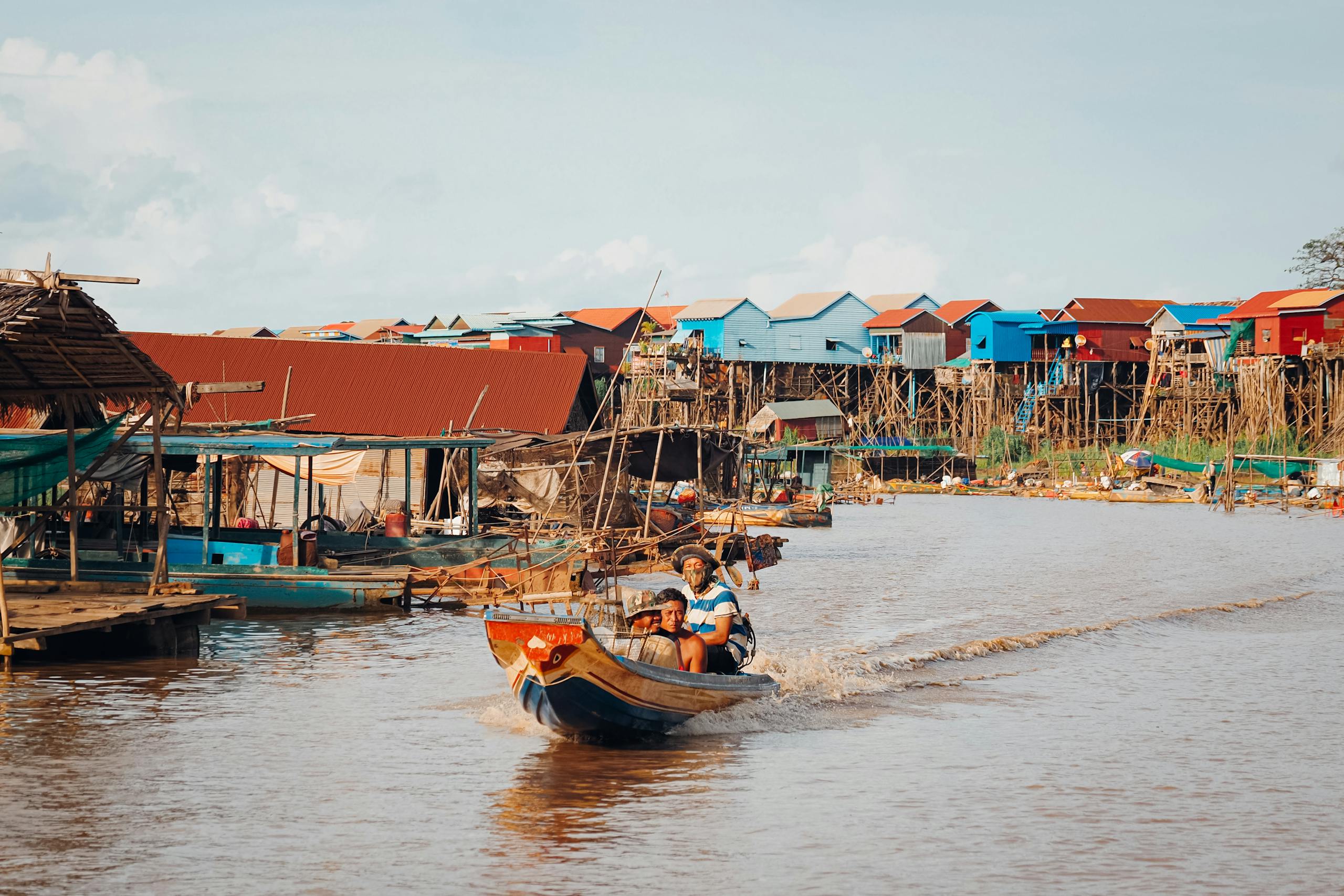 Vibrant boats and stilt houses in Kampong Khleang, capturing traditional Cambodian riverside living.